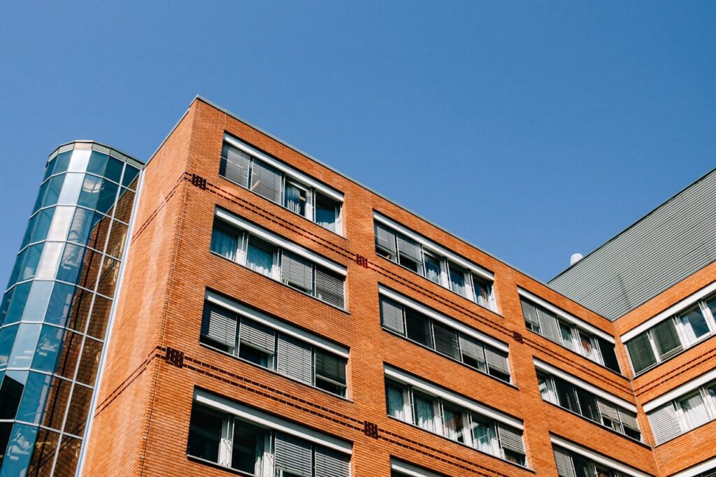 From below of contemporary high apartment building located in residential district against blue sky