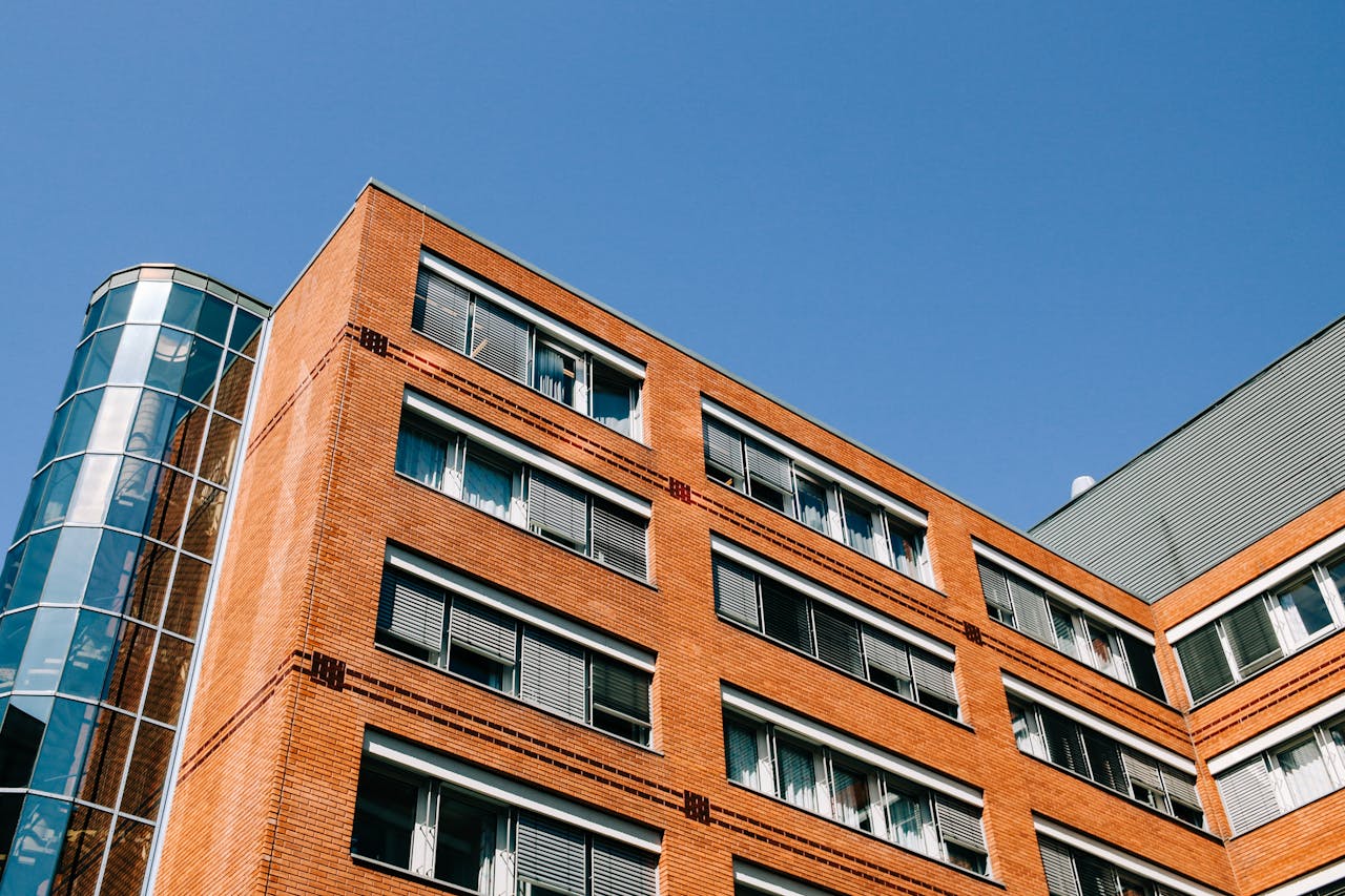 From below of contemporary high apartment building located in residential district against blue sky